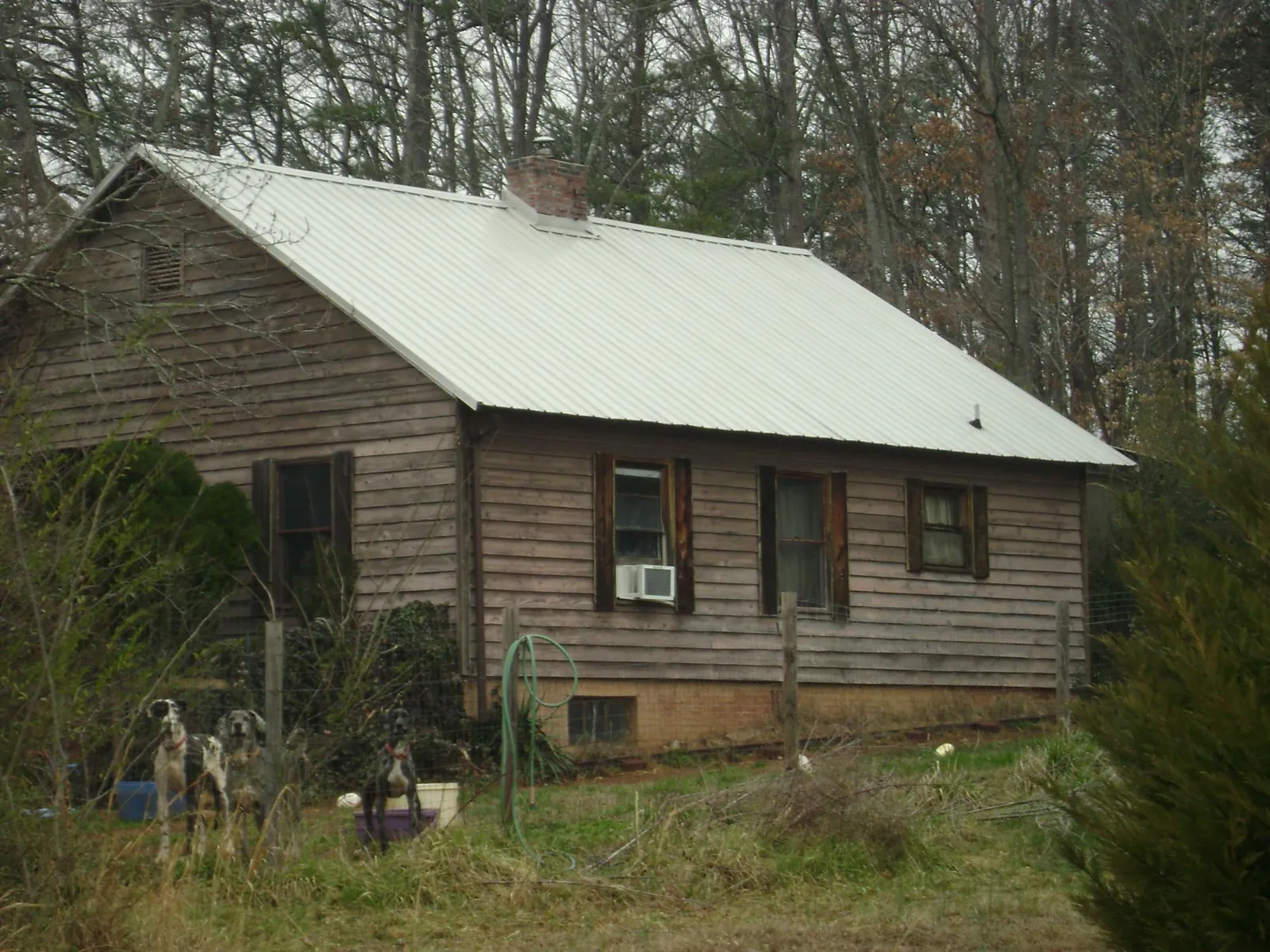 White metal roof on an old wood sided farmhouse, from a Metal Roof Installation job in Kingsford Heights